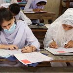 Students solving question paper during annual examination of HSC (Part-I) at Government Girls High School, Latifabad