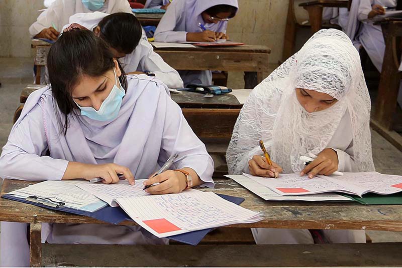 Students solving question paper during annual examination of HSC (Part-I) at Government Girls High School, Latifabad