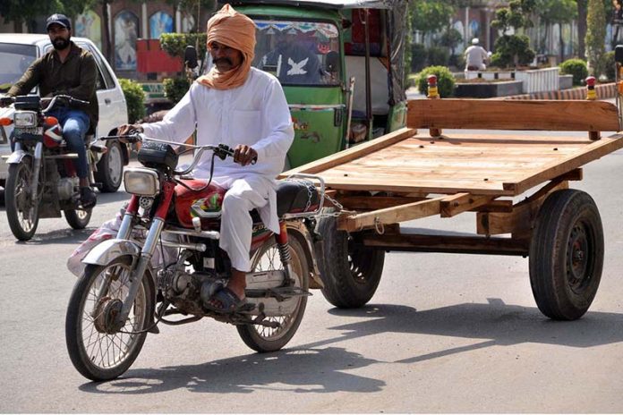 A motorcycle cart holder heading towards his destination at College road