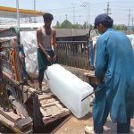 Laborers are loading ice blocks to a delivery van at G.T Road
