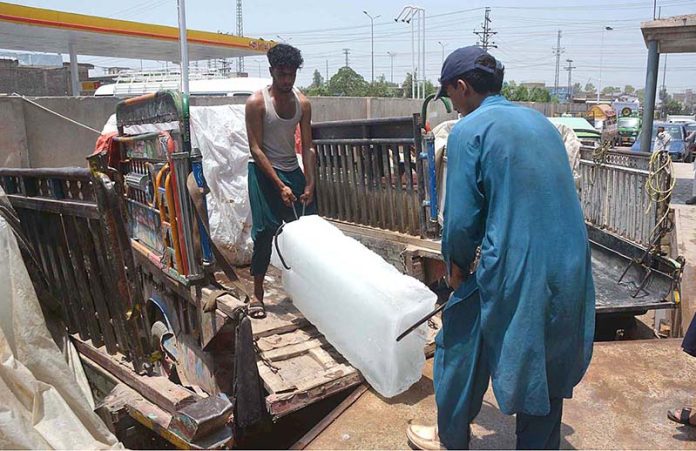 APP11-230623Peshawar Laborers are loading ice blocks to a delivery van at G.T Road