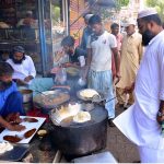 Vendor busy in preparing the traditional food item poori for selling to customers at his shop