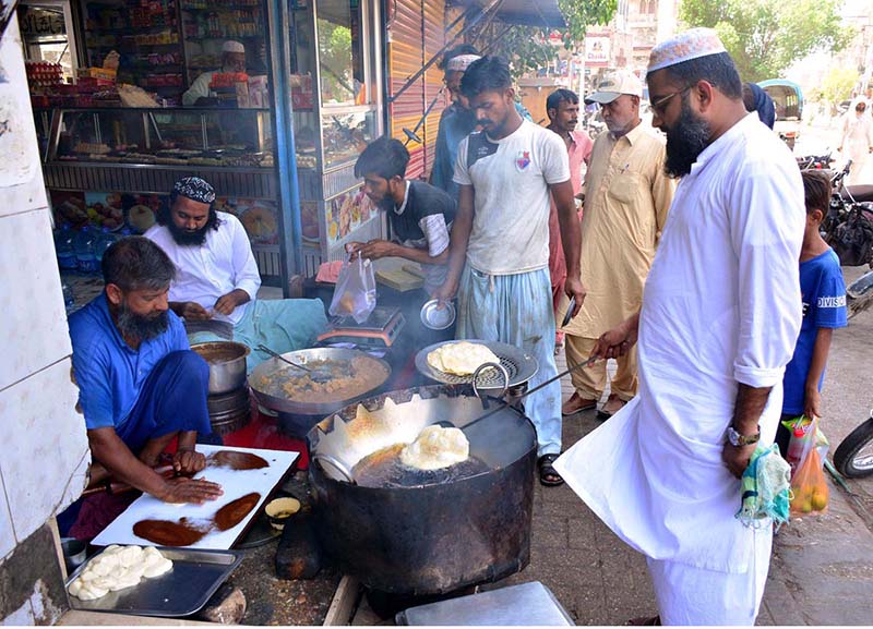 Vendor busy in preparing the traditional food item poori for selling to customers at his shop