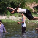 Youngsters enjoy jumping and bathing in the Rawal dam adjacent Nallah during a hot day in the Federal Capital
