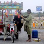 A tri-cycle delivery cart holder purchasing fuel from an illegal petrol selling point along the roadside setup needs the attention of concerned authorities