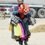 A man selling decorative stuff while shuttling on the road