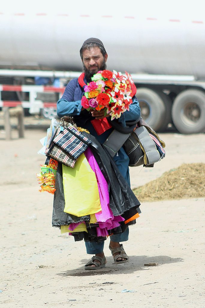 A man selling decorative stuff while shuttling on the road