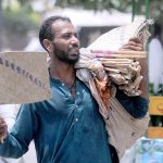 A street hawker selling handmade fans while shuttling on Hussain Agahi Road