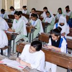 Students solving question paper during annual examination of HSSC (Part-II) at Government Degree Girls College at Latifabad