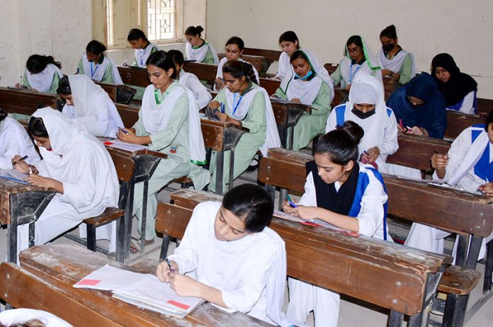 Students solving question paper during annual examination of HSSC (Part-II) at Government Degree Girls College at Latifabad