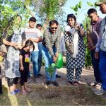 Administrator of HMC Mohammad Farooq khan showering water on the plant after planting during plantation campaign organized by Caritas Pakistan at nursery park