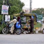 A vendor is selling sugarcane juice at his roadside setup