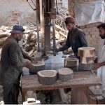 Carpenter busy in preparing wooden bases to be used by butchers to cut meat in pieces on sacrifice day of Eid ul-Azha
