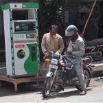 A motorcyclist taking fuel from an illegal petrol pump at the roadside