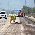 The construction site of Attock bridge road presents an active scene of ongoing work, with workers and machinery engaged in building the bridge infrastructure