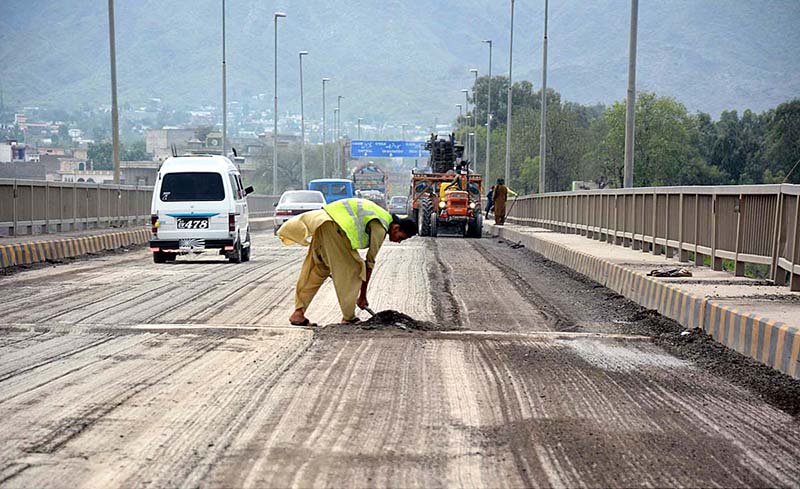 The construction site of Attock bridge road presents an active scene of ongoing work, with workers and machinery engaged in building the bridge infrastructure