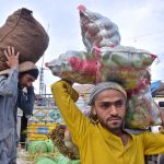 Laborers busy in unloading the seasonal vegetable from delivery truck at Vegetable Market
