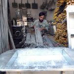 A vendor arranging and selling iron skewers and barbecue stoves ahead of Eid ul Azha at Reti bazaar