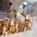 vendor selling wooden bases to be used by butchers to cut meat in pieces on sacrifice day of Eid ul-Azha