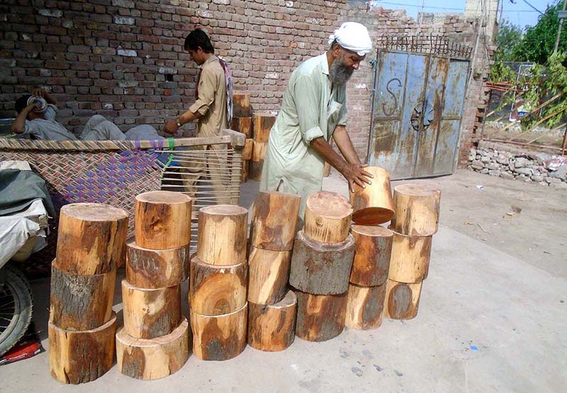 vendor selling wooden bases to be used by butchers to cut meat in pieces on sacrifice day of Eid ul-Azha