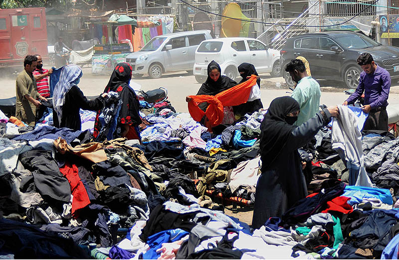 People selecting and purchasing old cloth from roadside vendors