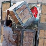 Worker busy in unloading room air coolers at his workplace in the Provincial Capital City