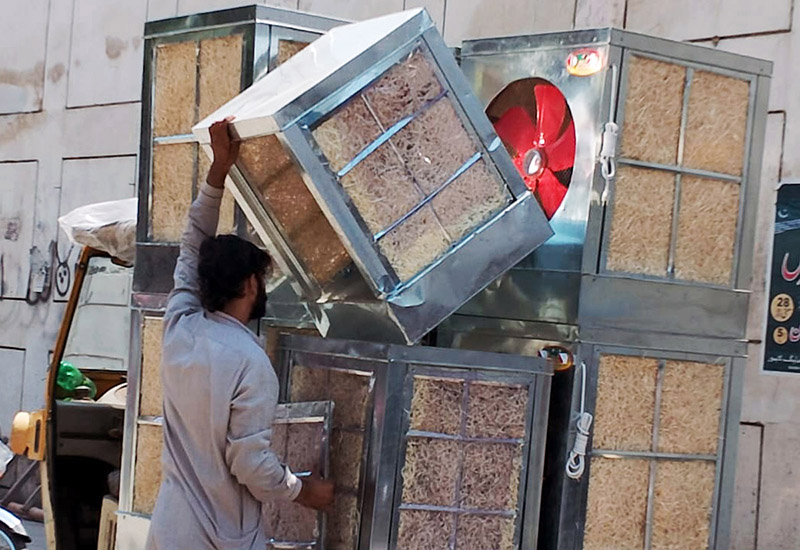 Worker busy in unloading room air coolers at his workplace in the Provincial Capital City