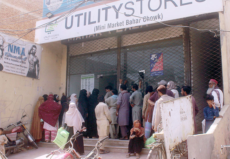 People standing in a queue waiting their turn outside Utility Store to purchase grocery items on subsidized rates at Masoom Shah Road