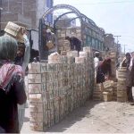 Laborers off loading fruit crates from delivery truck at the fruit market