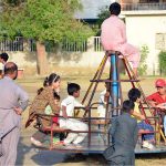 Children enjoying the swing at local park near Latifabad