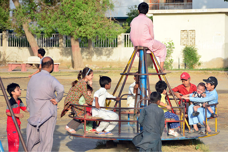 Children enjoying the swing at local park near Latifabad