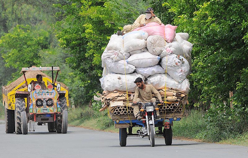 A person riding an overloaded tricycle rickshaw which may cause any mishap