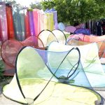 A vendor is busy in arranging and displaying Mosquito Nets to attract customers at his roadside setup