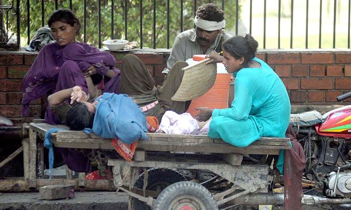 Family is resting under shade during hot weather in the city