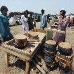Vendors displaying wooden pieces for used during sacrifice at Animal Market Hathri Bypass in connection with upcoming Eid ul Azha