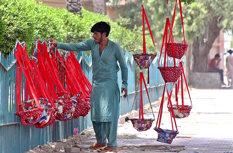 A vendor displaying swings for children to attract customers at his roadside setup