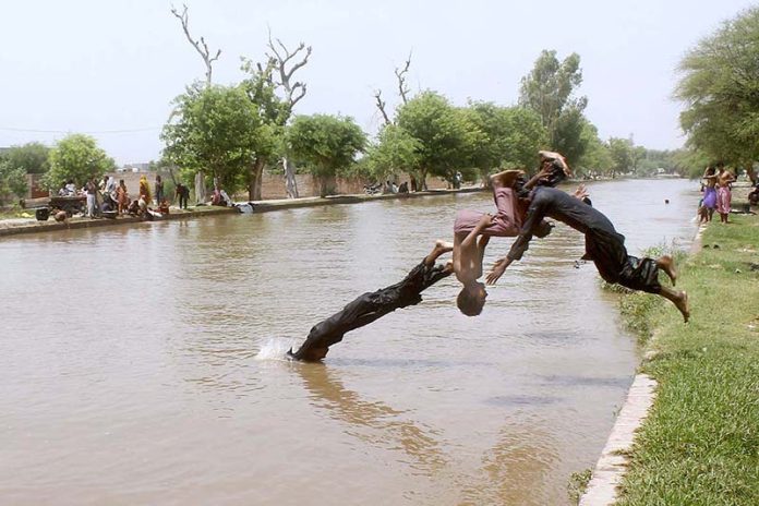Children diving in canal to get relief from the scorching hot weather in the city