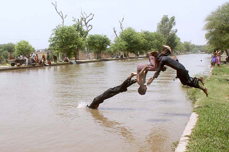 Children diving in canal to get relief from the scorching hot weather in the city