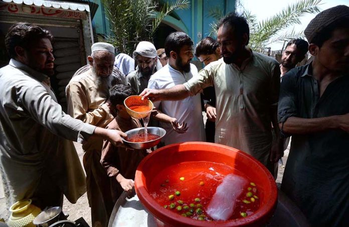 Volunteers are distributing sweet water among the people during hot weather in the city