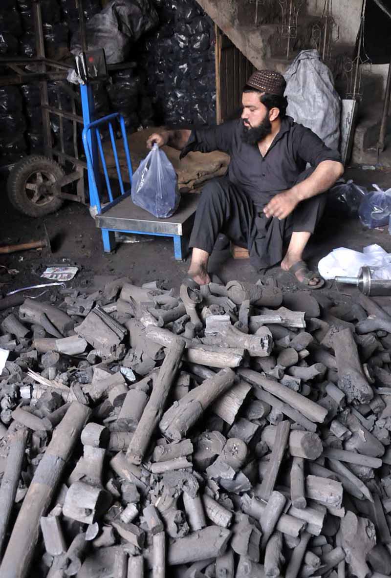 June 25 – A vendor selling coal to attract customers at his workplace for upcoming Eid ul-Azha