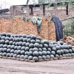 A vendor waiting for customers to sell watermelon at his roadside setup