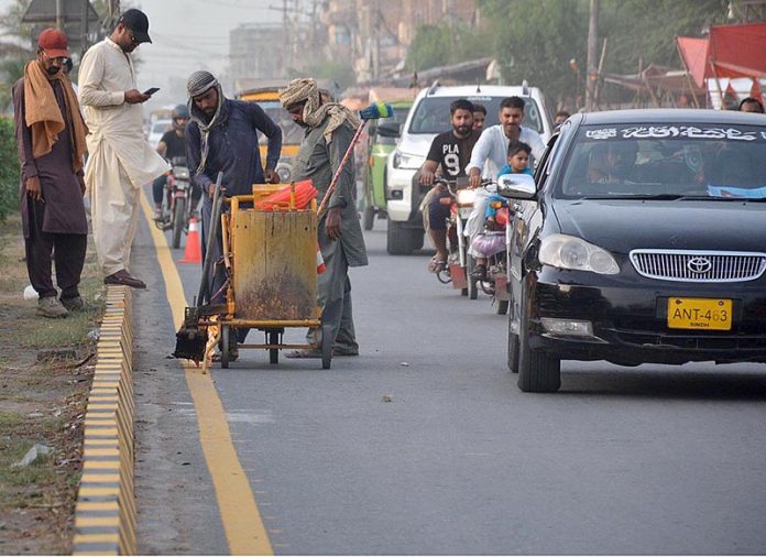 Workers marking road lines on Jhumra Road