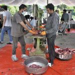 Butchers busy in cutting meat into pieces with machine after slaughtering sacrificial animal on the 1st day of Eid Ul Azha at Jamia Masjid I-9/4