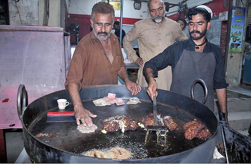 Vendors making traditional food item Chapli kabab at his workplace for costumers near Ghouri town at Federal Capital
