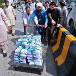 Staffers pushing cart loaded with copies of Pakistan Economy Survey 2022-23 at Parliament House