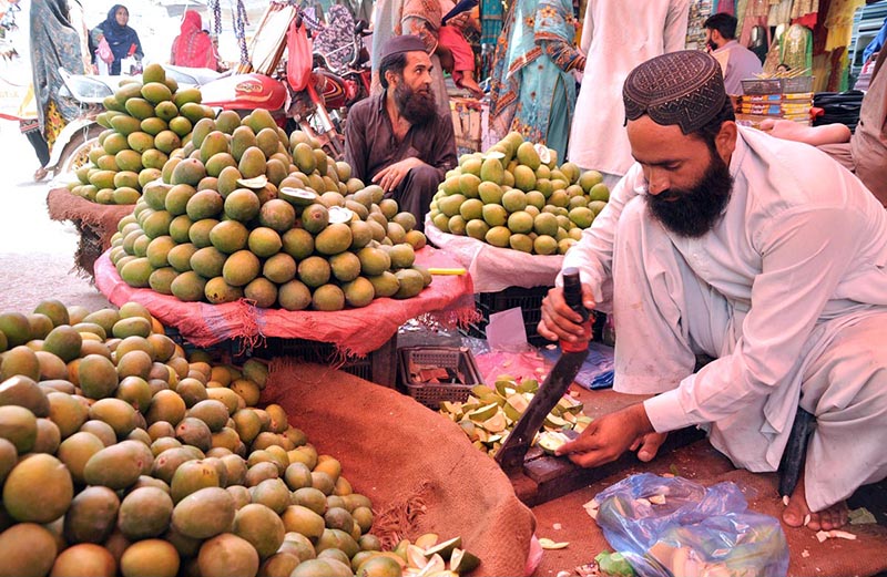 A vendor cutting achari mangoes at Gole bazar