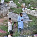 People offering fateha on the graves of their family members in graveyard on the occasion of Eid ul Azha