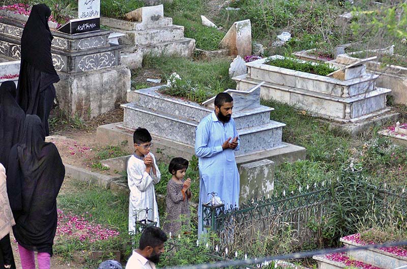 People offering fateha on the graves of their family members in graveyard on the occasion of Eid ul Azha