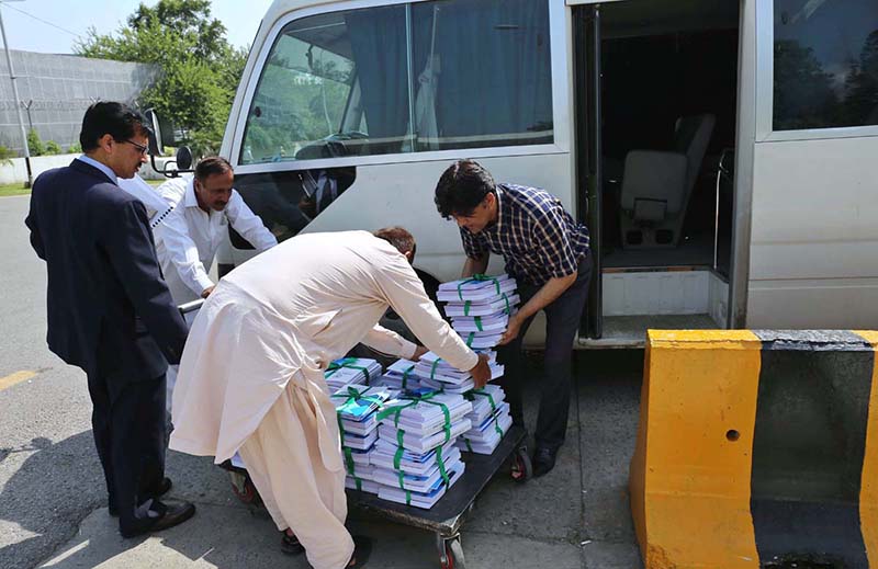 Staffers pushing cart loaded with copies of Pakistan Economy Survey 2022-23 at Parliament House