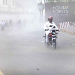 Motorcyclists strugling to move during a wind strom in the city
